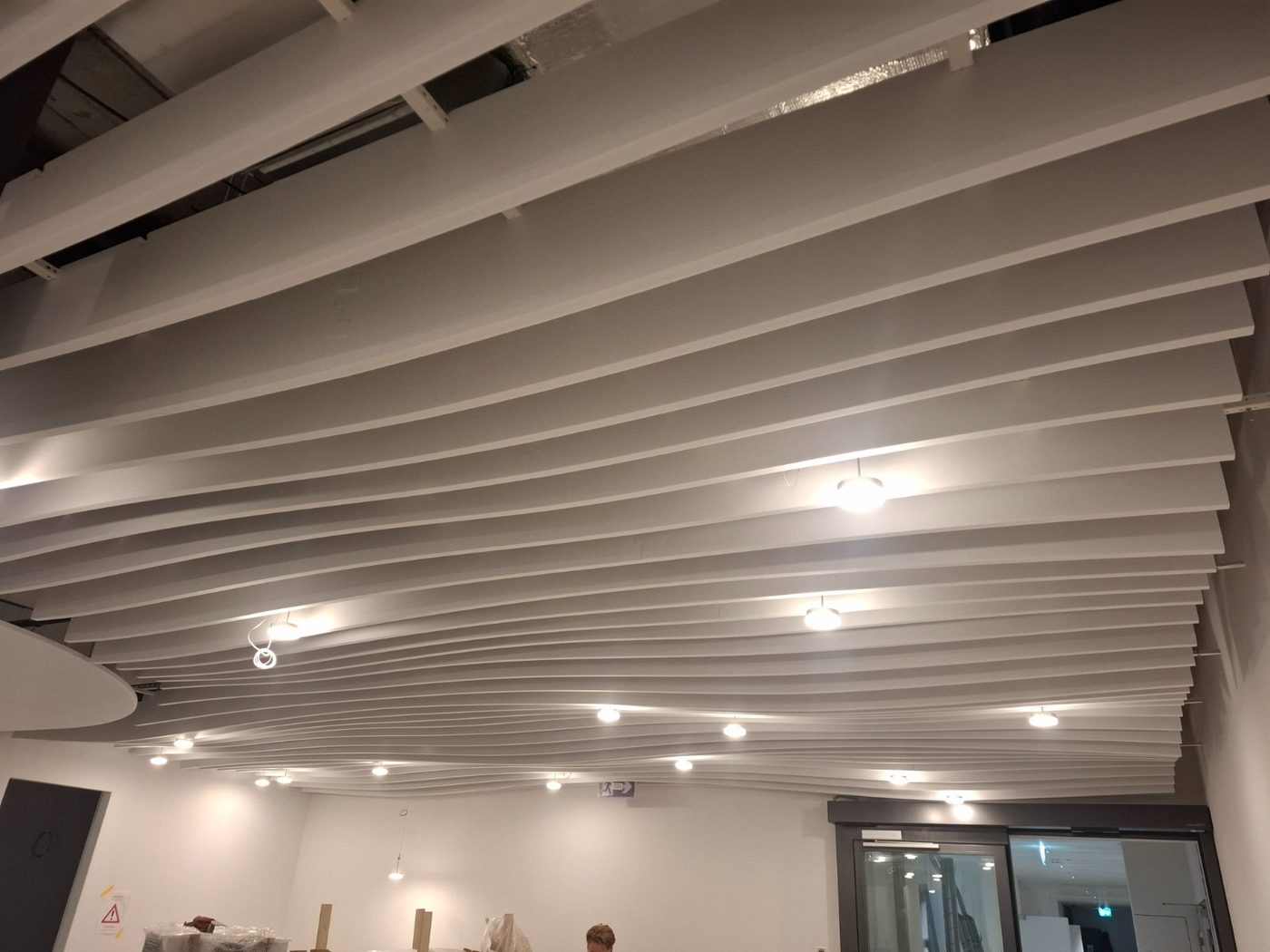 Plafond acoustique ondulé en baffles avec spots intégrés, Bienne
